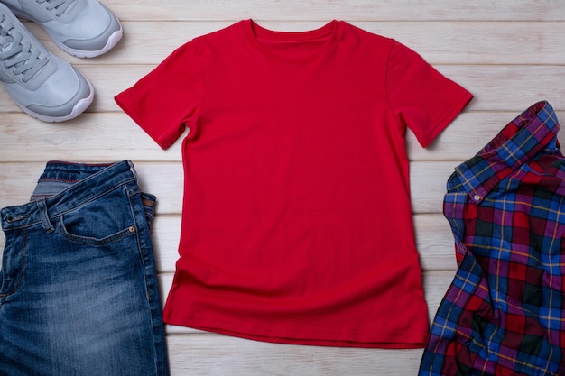 Foto mockup di maglietta rossa unisex in cotone con scarpe da ginnastica grigie e jeans modello di t-shirt di design con stampa a t-shirt mock up