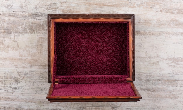 Photo a red velvet box with a wooden lid sits on a concrete wall.