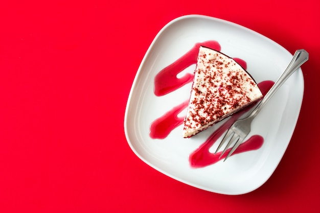 Fetta di torta di velluto rosso su sfondo rosso