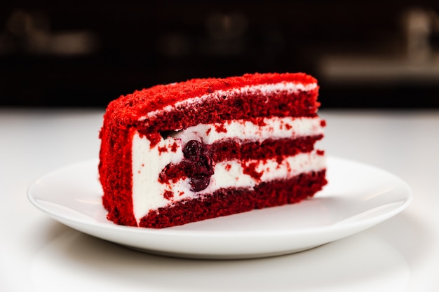 Red velvet cake with cherry on a white plate