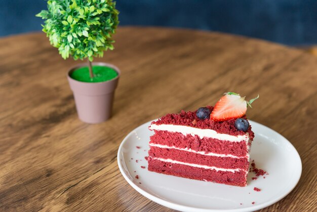 Red velvet cheesecake op houten tafel in café.