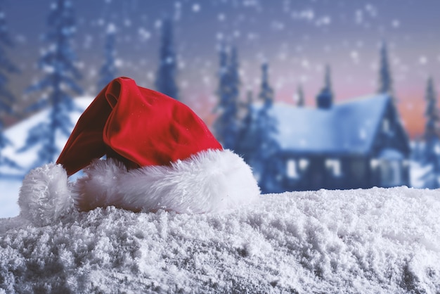 Photo red velvet christmas hat of santa claus on the snow