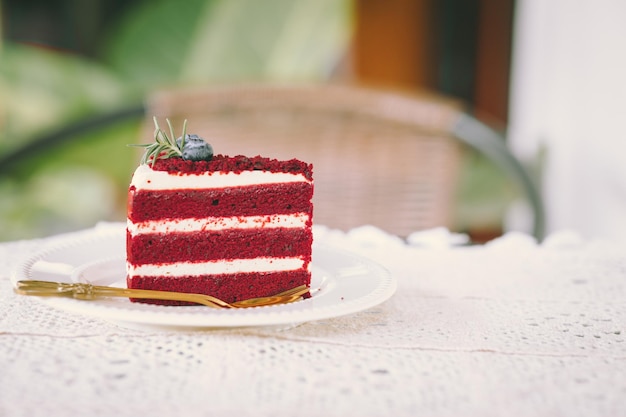 Красный бархатный кремовый торт крупным планом на столике в кафе десертная еда сладкий вкусный винтажный тон