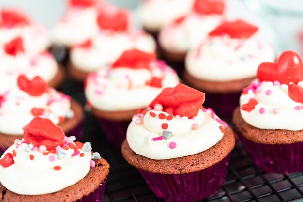 Red velvet cupcakes with cream cheese frosting and decorates with heart and kiss shaped red chocolates