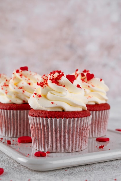 Cupcake di velluto rosso con glassa di formaggio a crema e cuori di zucchero rosso dessert per il giorno di san valentino