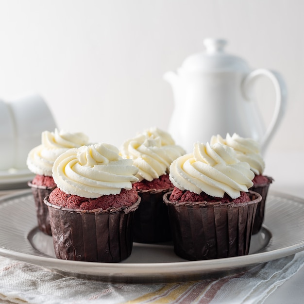 Red velvet cupcakes with white cream on top.