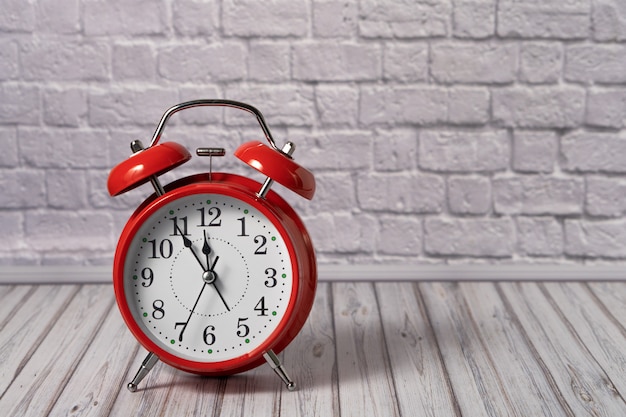 Red vintage alarm clock on a wooden table. Copy space