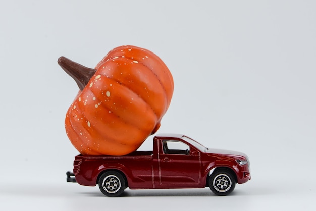 red vintage toy car with small Halloween pumpkins on the roof