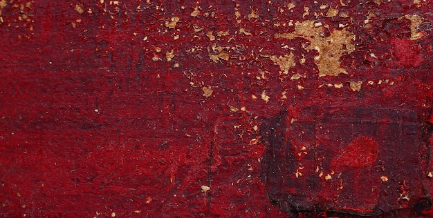 ペイントが剥がれた赤い壁に「」という文字が書かれています。