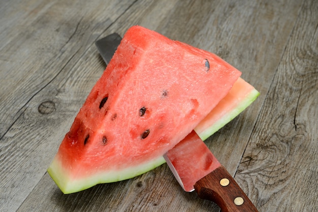 Red watermelon sliced on wooden table