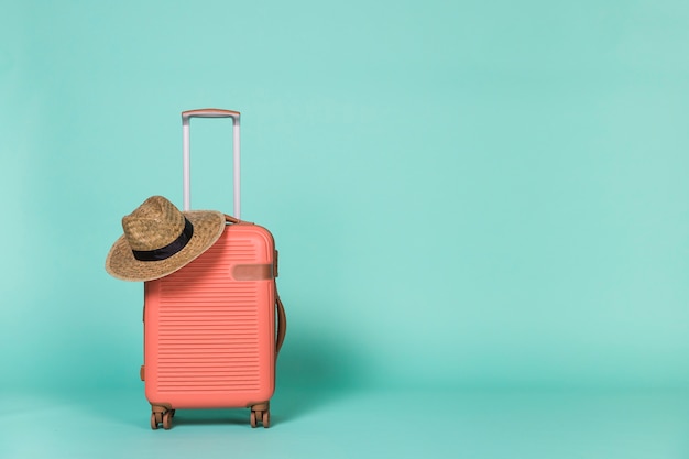 Photo red wheeled suitcase with hat