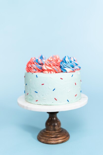 Red, white, and blue round cake frosted with buttercream frosting.