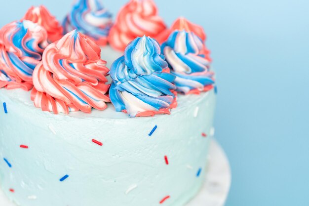 Red, white, and blue round cake frosted with buttercream frosting.