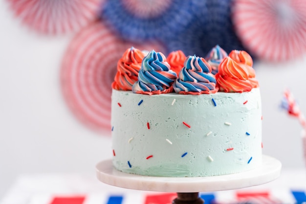 Red, white, and blue round vanilla cake with buttercream frosting for July 4th celebration.