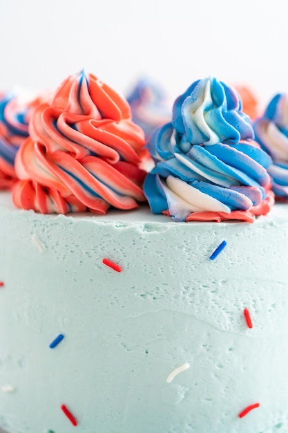Red, white, and blue round vanilla cake with buttercream frosting for July 4th celebration.