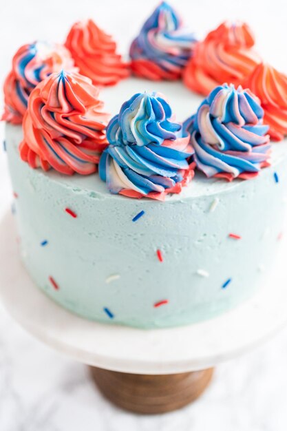 Red, white, and blue round vanilla cake with buttercream frosting for July 4th celebration.