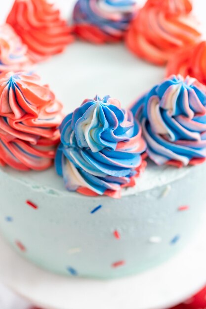 Red, white, and blue round vanilla cake with buttercream frosting for July 4th celebration.