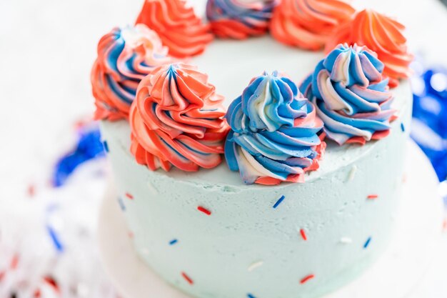 Red, white, and blue round vanilla cake with buttercream frosting for July 4th celebration.