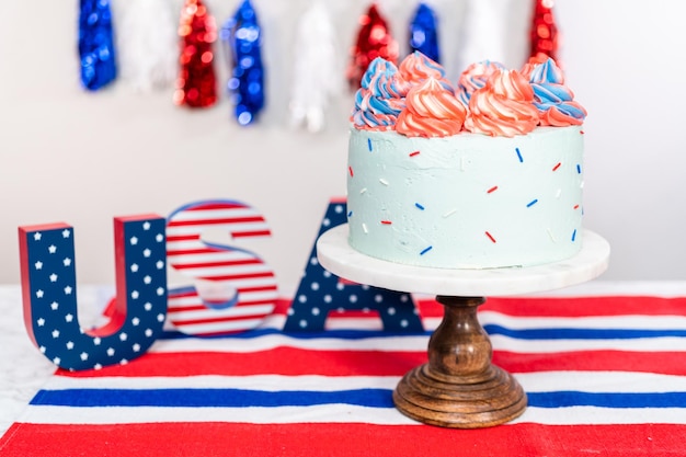 Red, white, and blue round vanilla cake with buttercream frosting for July 4th celebration.