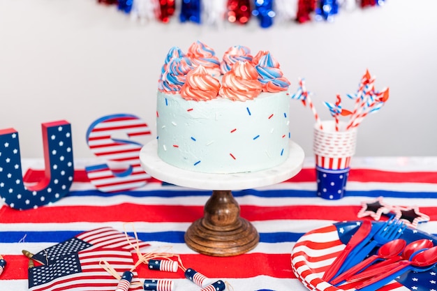 Red, white, and blue round vanilla cake with buttercream frosting for July 4th celebration.