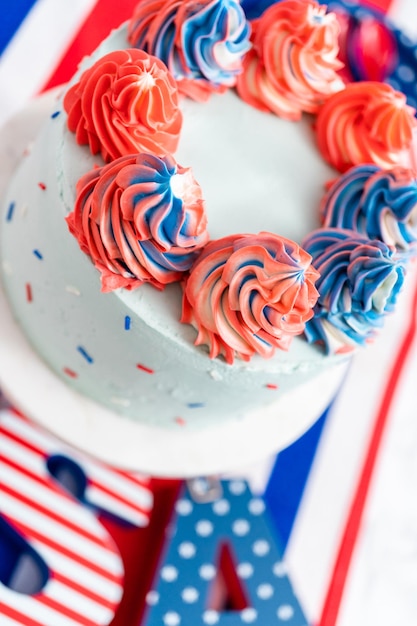 Red, white, and blue round vanilla cake with buttercream frosting for July 4th celebration.