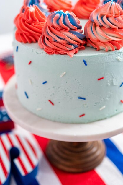 Red, white, and blue round vanilla cake with buttercream frosting for July 4th celebration.