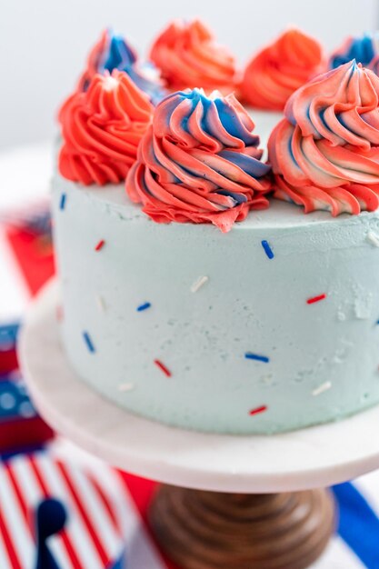 Red, white, and blue round vanilla cake with buttercream frosting for July 4th celebration.