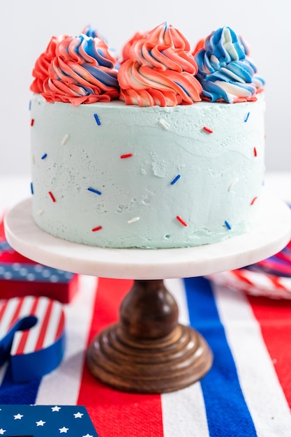 Red, white, and blue round vanilla cake with buttercream frosting for July 4th celebration.