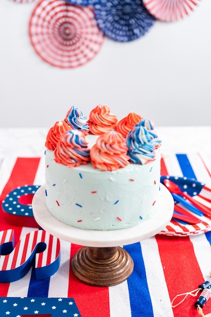 Red, white, and blue round vanilla cake with buttercream frosting for July 4th celebration.