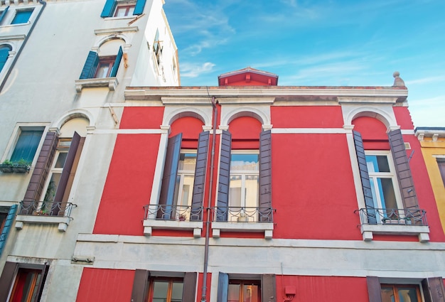 Red and white buildings under a blue sky in Venice Italy