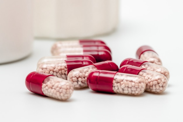 Red and white capsules with blank plastic bottle