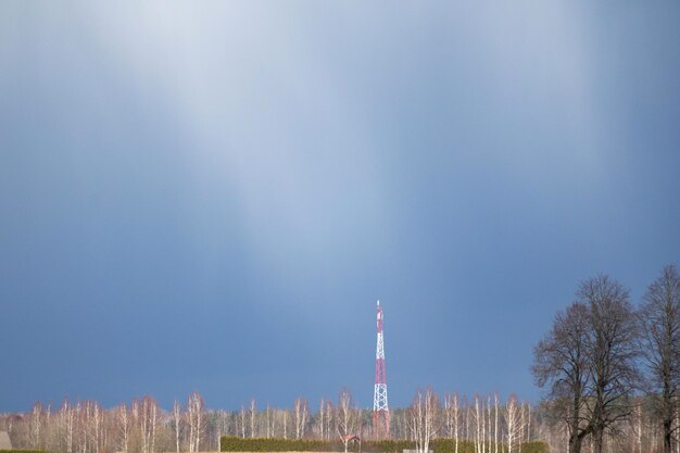 a red and white cell phone tower in a park