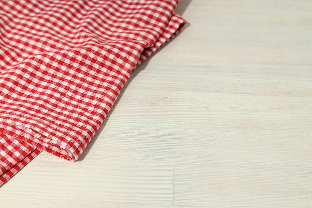 Red and white checkered tablecloth on wooden background