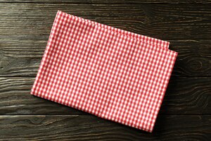 Red and white checkered tablecloth on wooden background