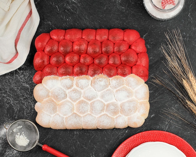 Red and white chigiri bubble bread, fresh viral white japanese\
bread, top view on black background. concept for indonesia\
independence day (17 agustus)