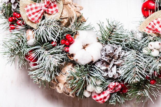 Red and white Christmas wreath with bows and cotton flowers