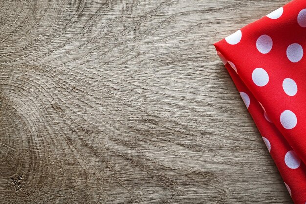 Red white cotton folded polkadot tablecloth on wooden board copy space