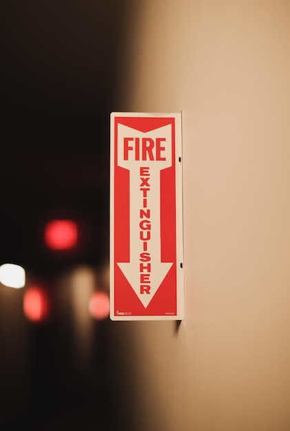 Photo a red and white fire extinguisher sign with an arrow pointing to the left.