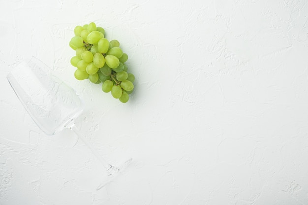 Red and white grapes set, green fruits, on white stone table, top view flat lay