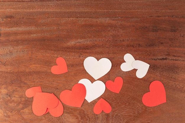 Red and white hearts of different sizes on rustic wooden background