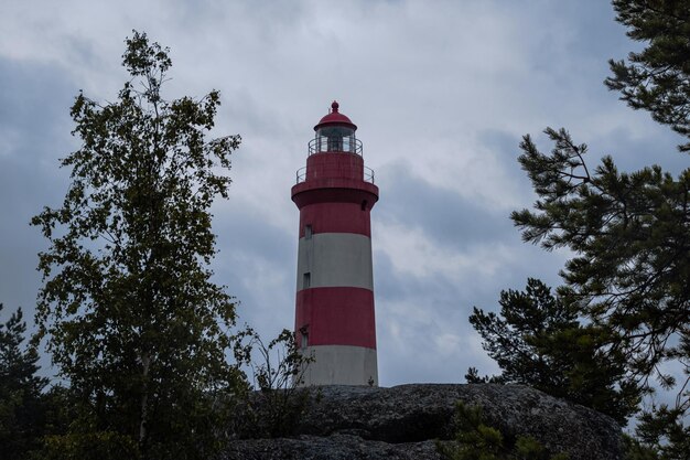 Photo red and white lighthouse on a rock in finland