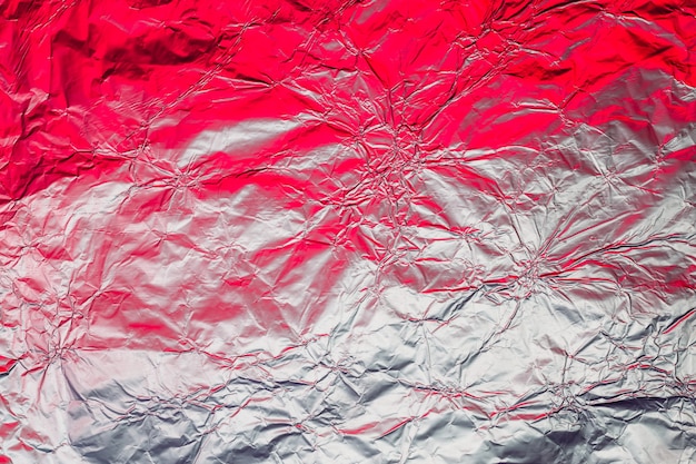 Red white metallic background made of neon lights foil. Trendy duotone texture.