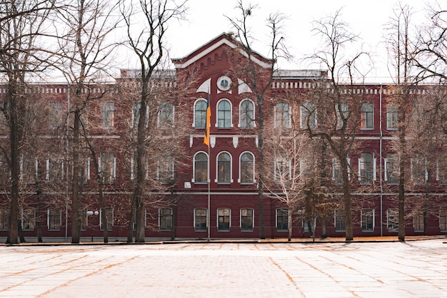 巨大なアーチ窓とレンガで作られたウクライナの大学の赤と白の古い建物 教育 ウクライナの旗 研究 学生 建築 遺産 歴史 史跡