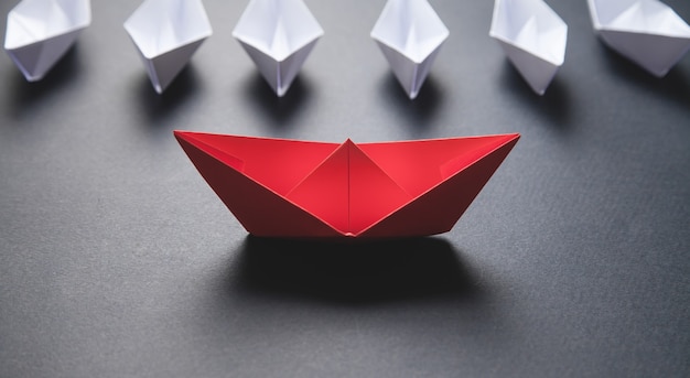 Red and white paper boat. Leadership concept