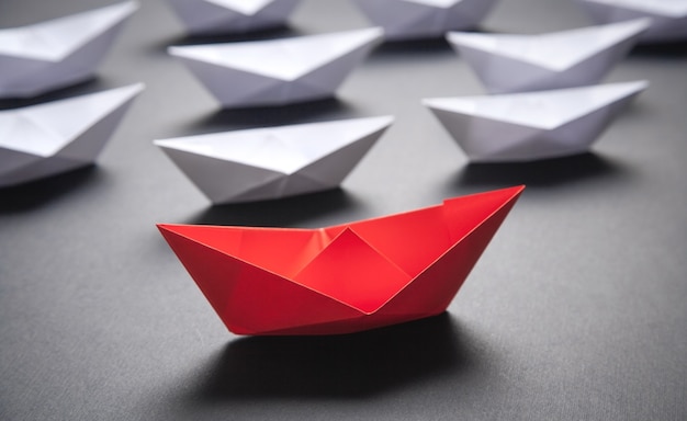 Red and white paper boat. Leadership concept