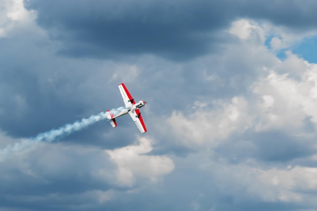 Red - white plane jets of fumes in flight in a blue sky close-up