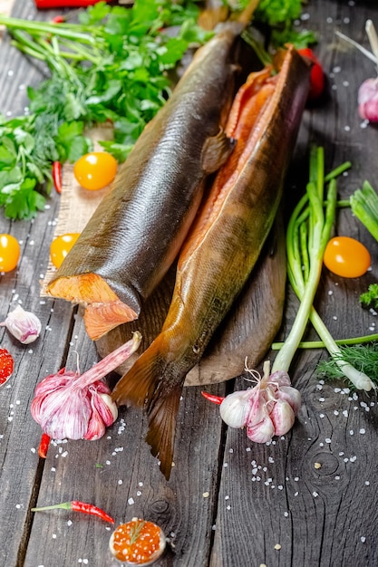 Red white sea river smoked fish lies on a vintage rustic cutting board and table, ropes, slices of