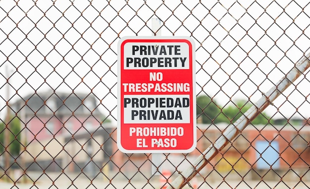 A red and white sign on a fence that says private property.