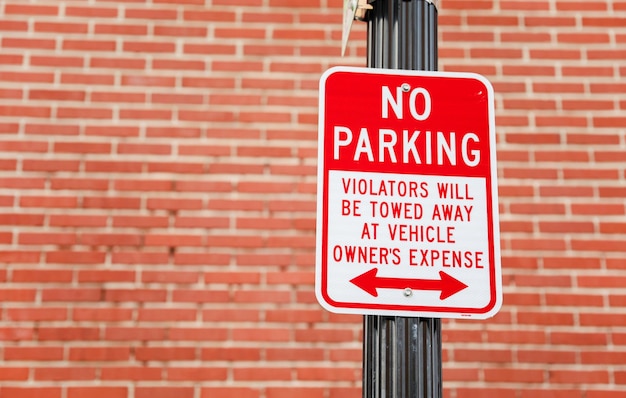 A red and white sign that says no parking at the top.