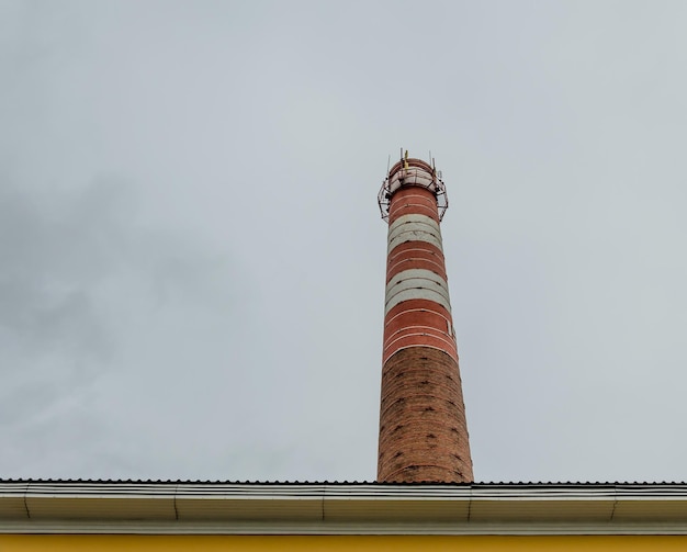 A red and white striped smokestack is visible above a brick building.